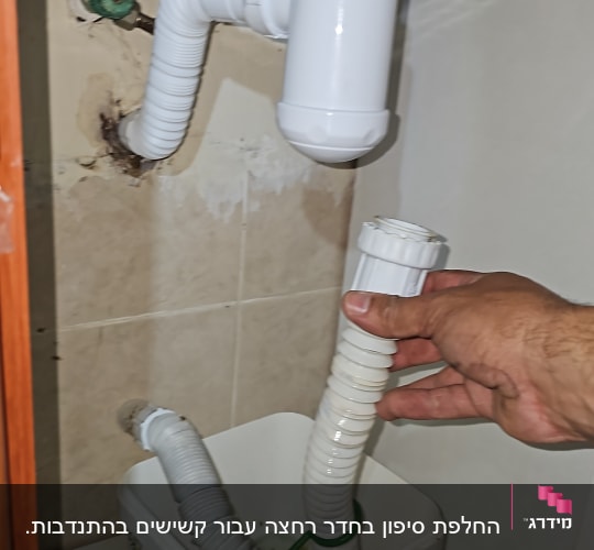 יד מחזיקה צינור מתחת לכיור עם דלי